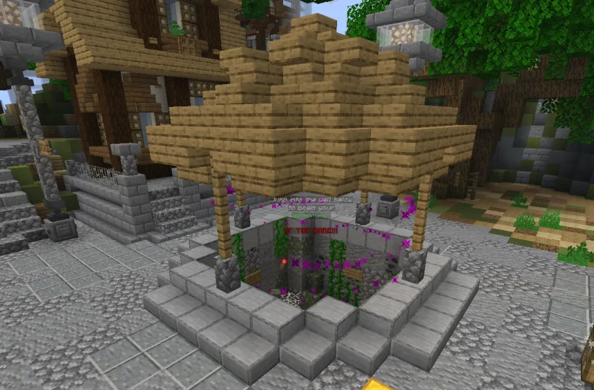 A Minecraft screenshot of a square stone well with a wooden roof in a cobblestone town square. Floating holographic text above the open pit reads "Jump into the well below to begin your adventure IF YOU DARE!!!" surrounded by purple magic particles.
